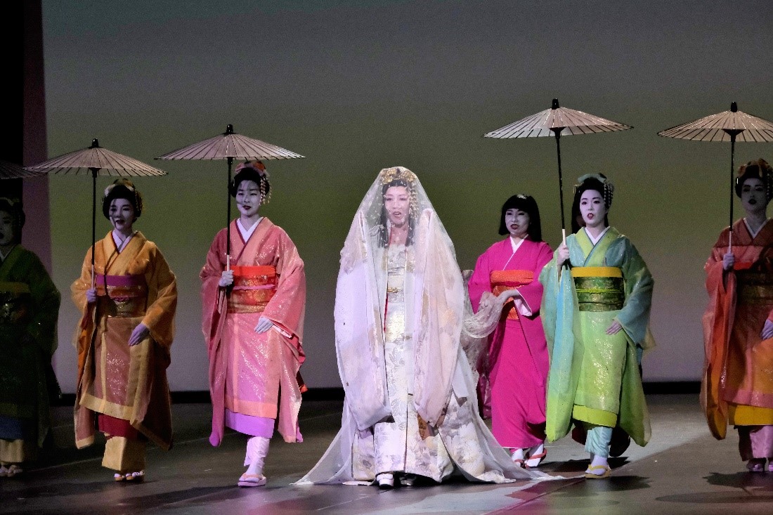 Women dressed in traditional Japanese garments singing on stage