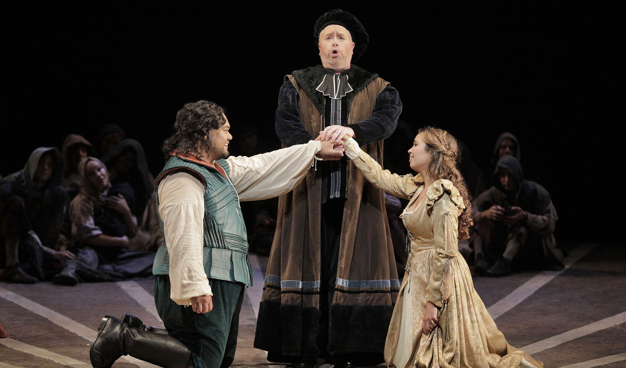 The Duke standing between Romeo and Juliet as they kneel with their hands joined.