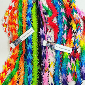 multi colored origami cranes stringed together.