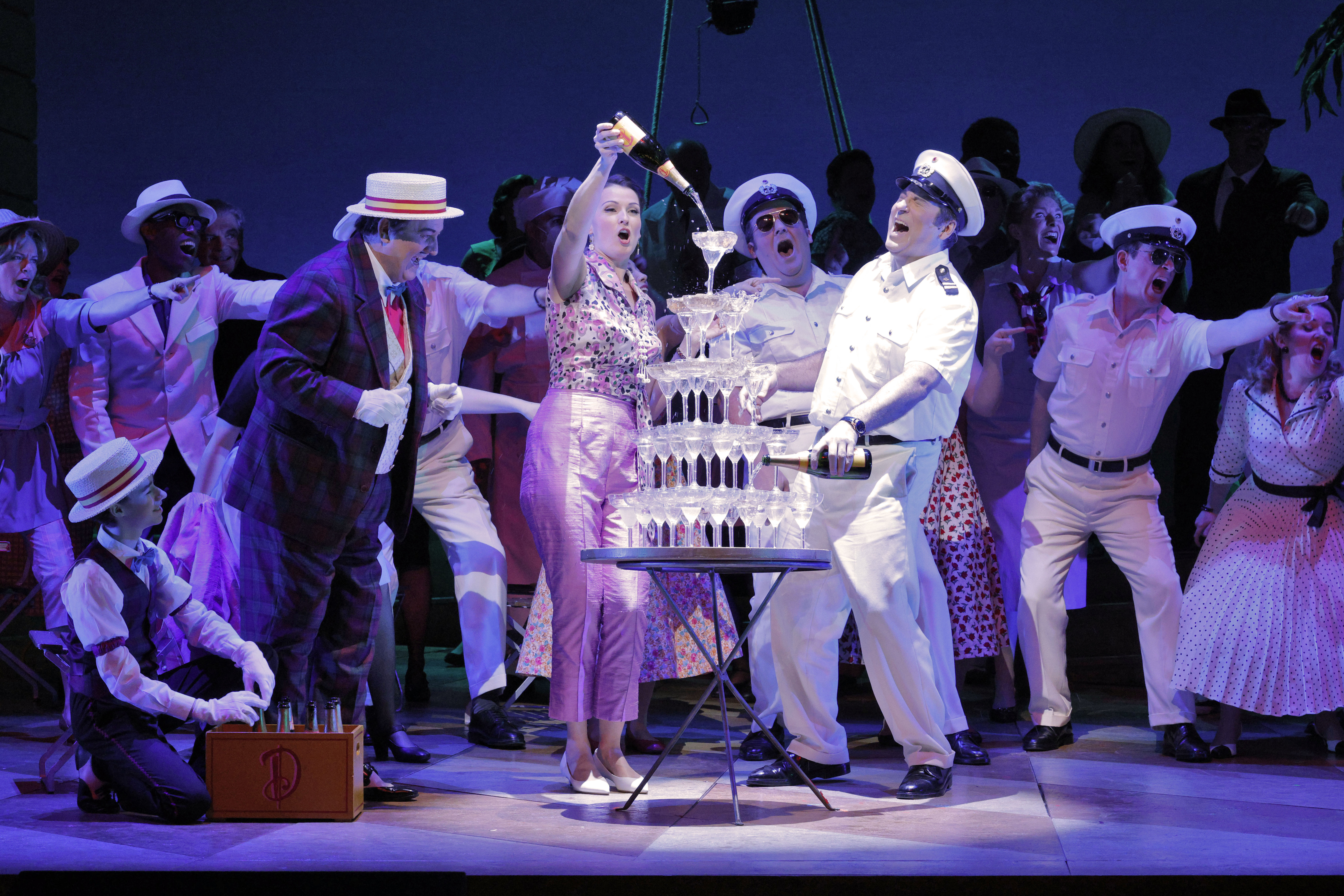 woman pouring champaign into tower of glasses
