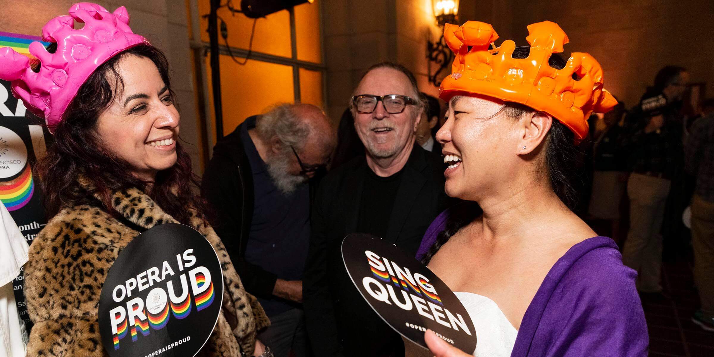 Two women wearing colorful blow-up crowns laughing_PC_Drew Altizer Photography.