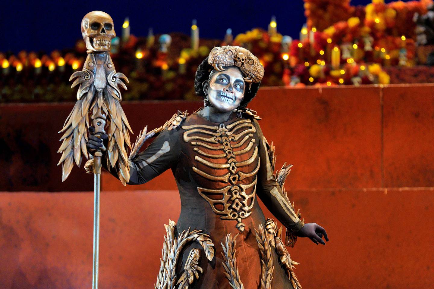 Scene from Frida of person dressed as a skeleton holding a scythe.