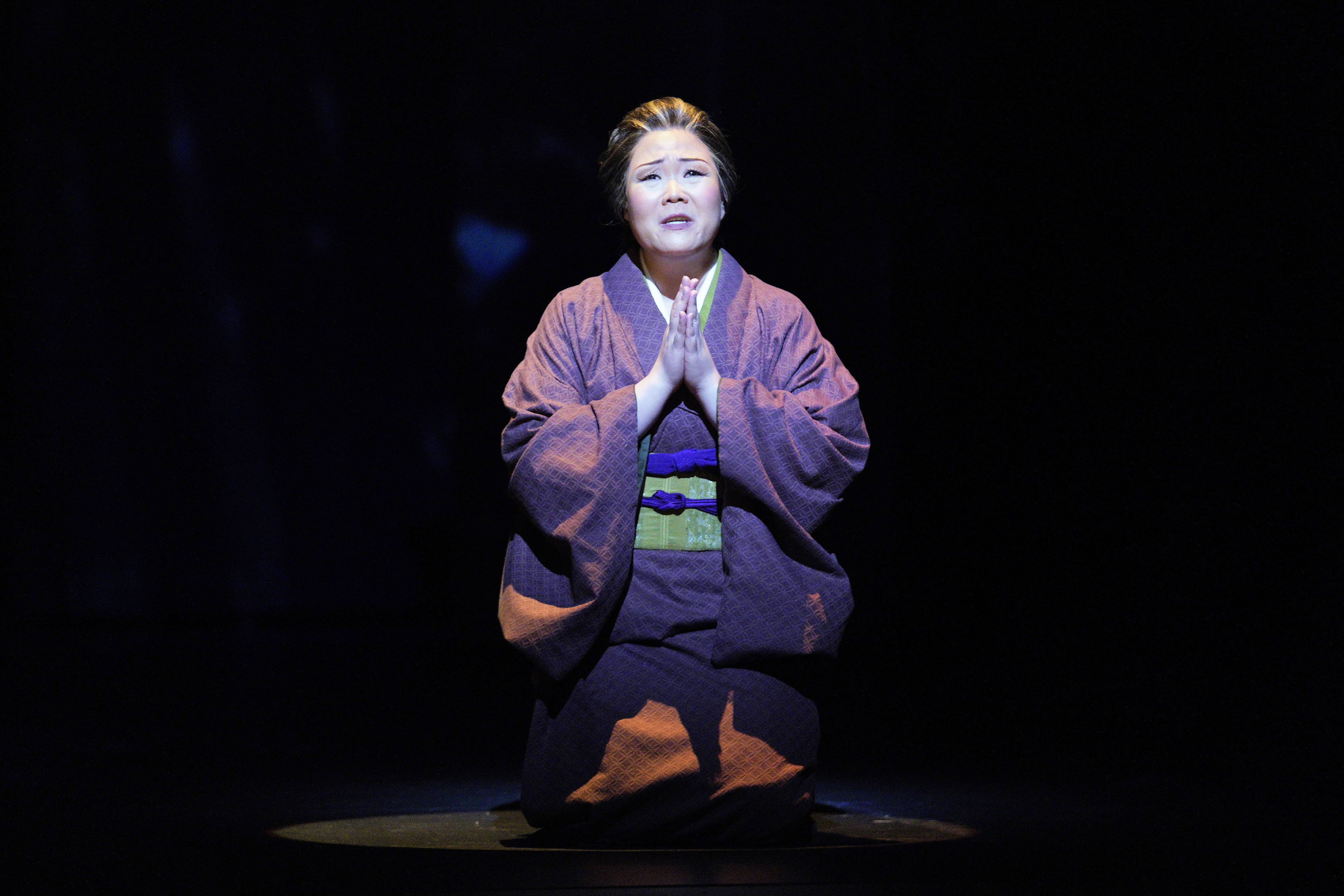 Madame Butterfly kneeling with praying hands