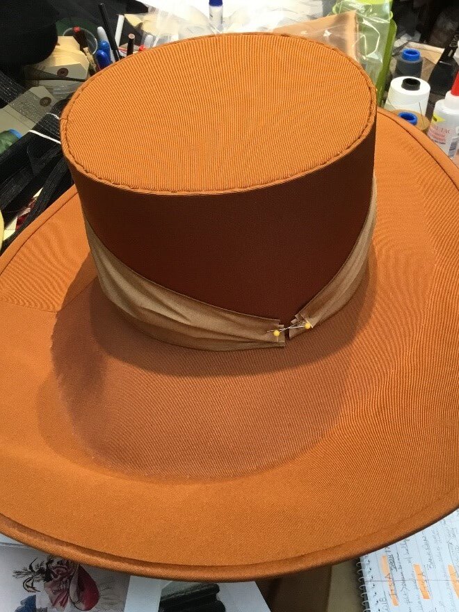 A hat in progress showing the fine stitching work.