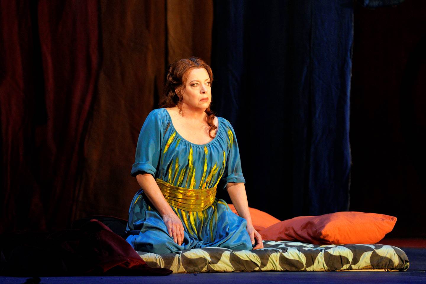 Die Frau ohne Schatten woman in blue dress sitting on bed