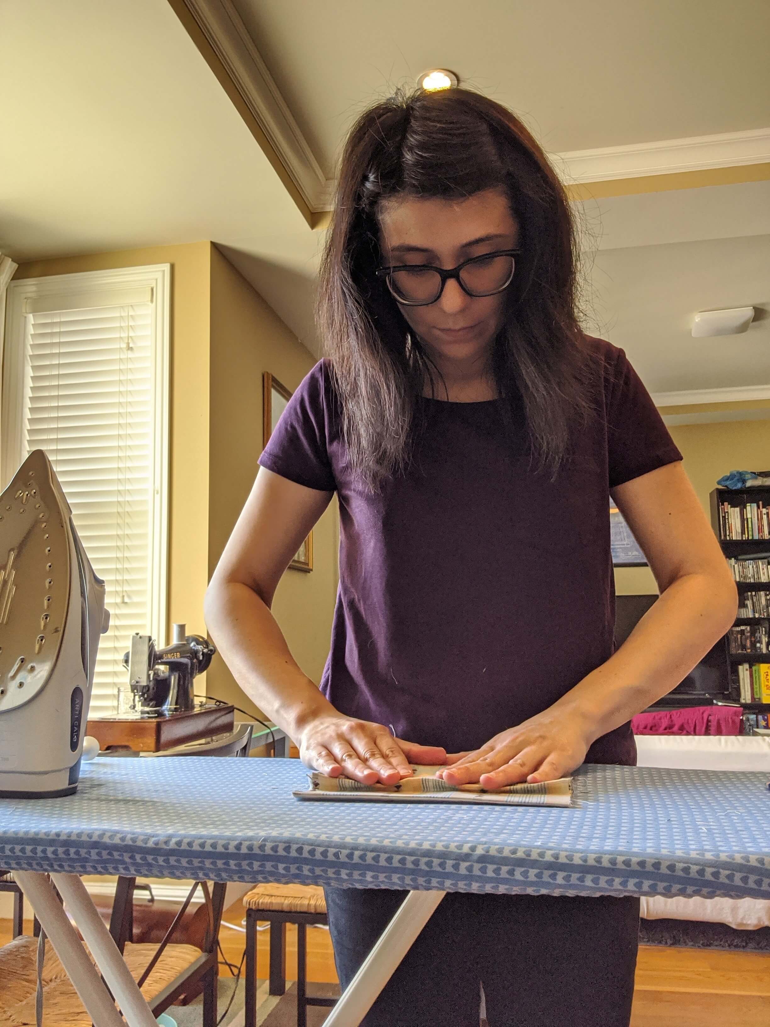 Costume Technician Aries Limon sets the pleats in place. 