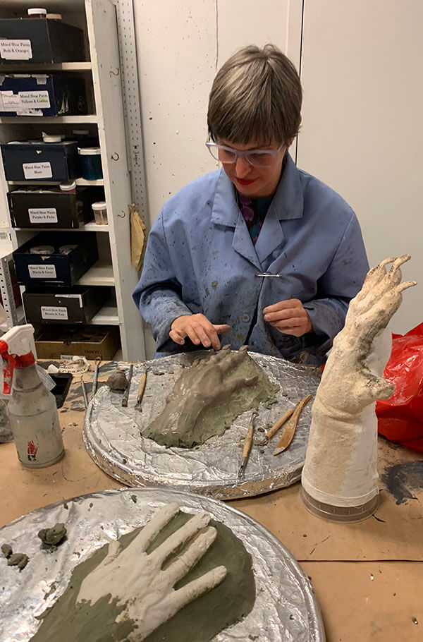 Senior Crafts Artisan Jersey McDermott finalizing a clay mold of the top of Robert&rsquo;s hands, replete with wonderfully long nails!