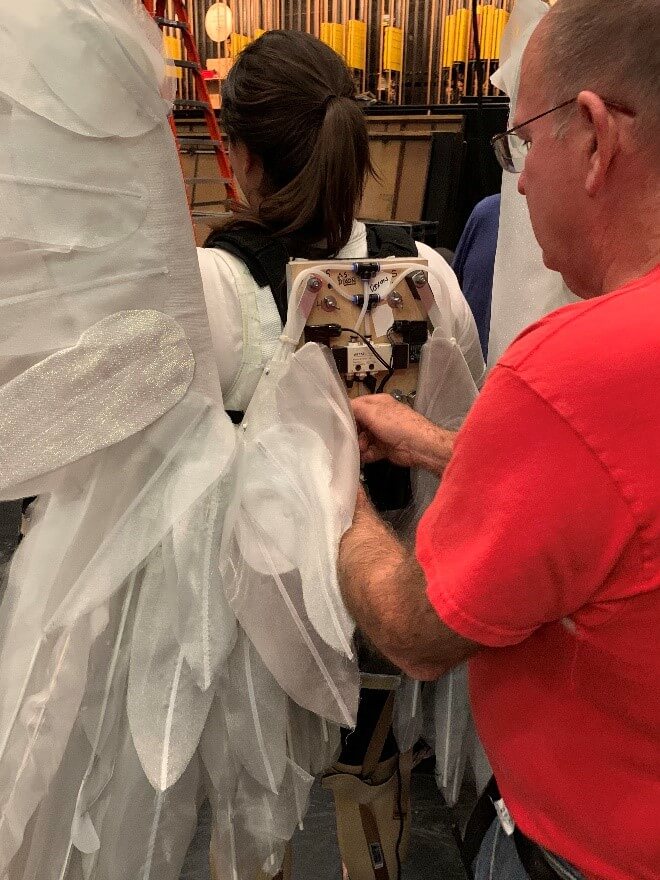 The Adler angels being prepped for their flying technical rehearsal, supported by members of the grips crew Paul Delatorre and Geoff Heron, and Jim Holden from our props crew.