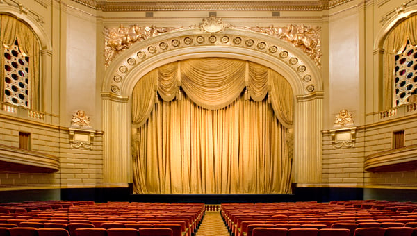WMOH interior view from back of house looking at the stage with the gold curtains closed.