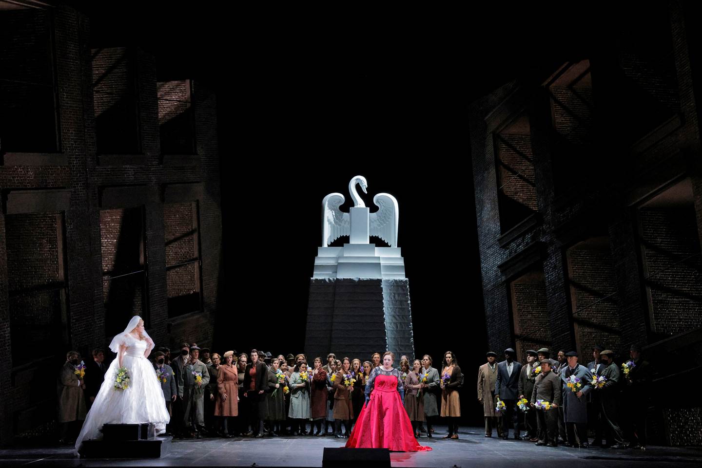 people on stage in front of statue