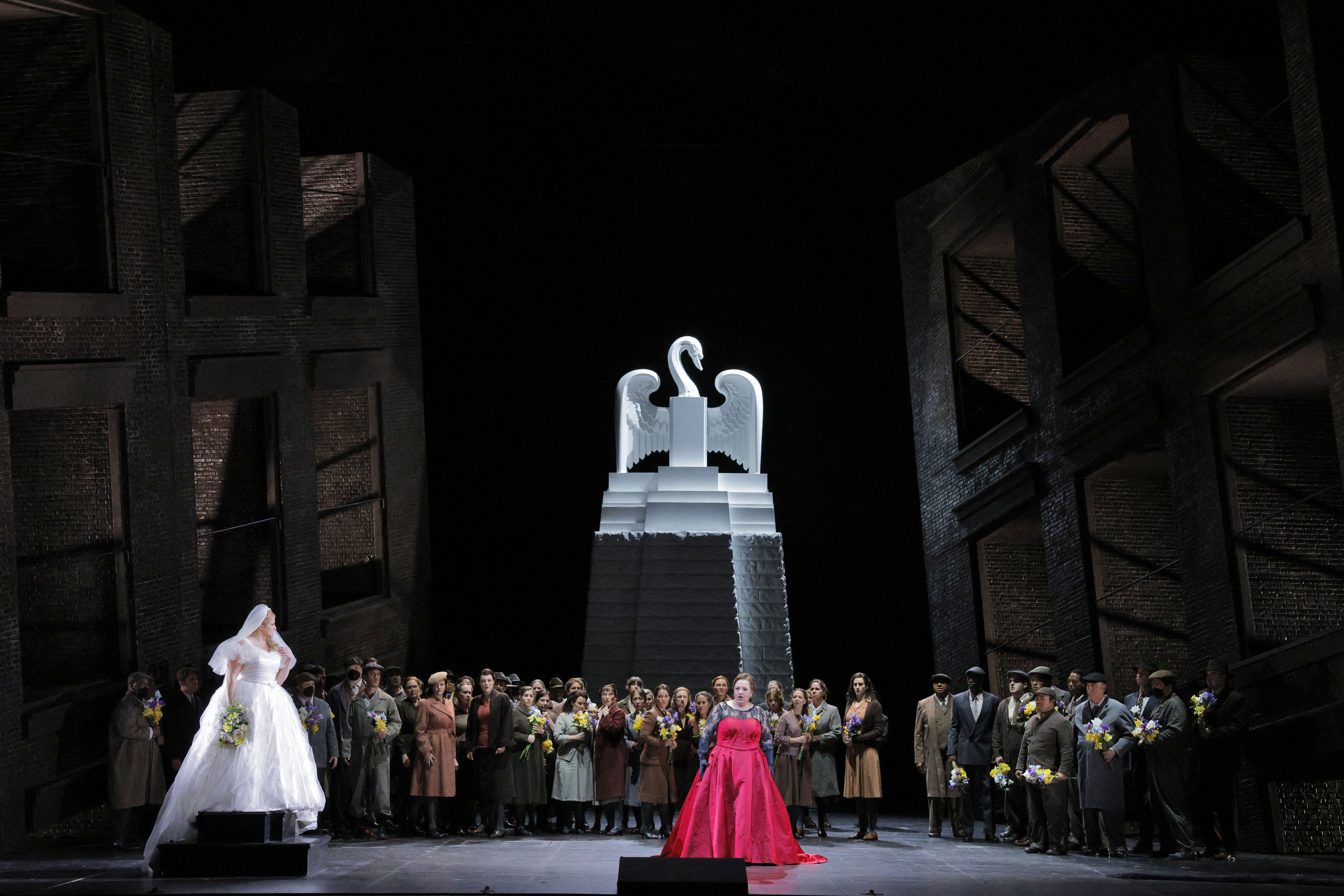 people on stage in front of statue