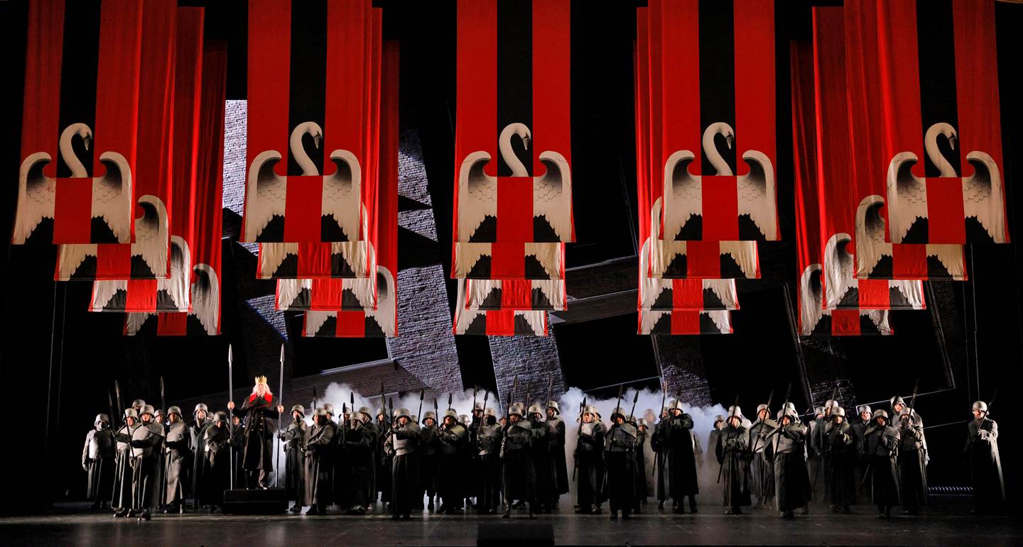 People on stage under lohengrin banners