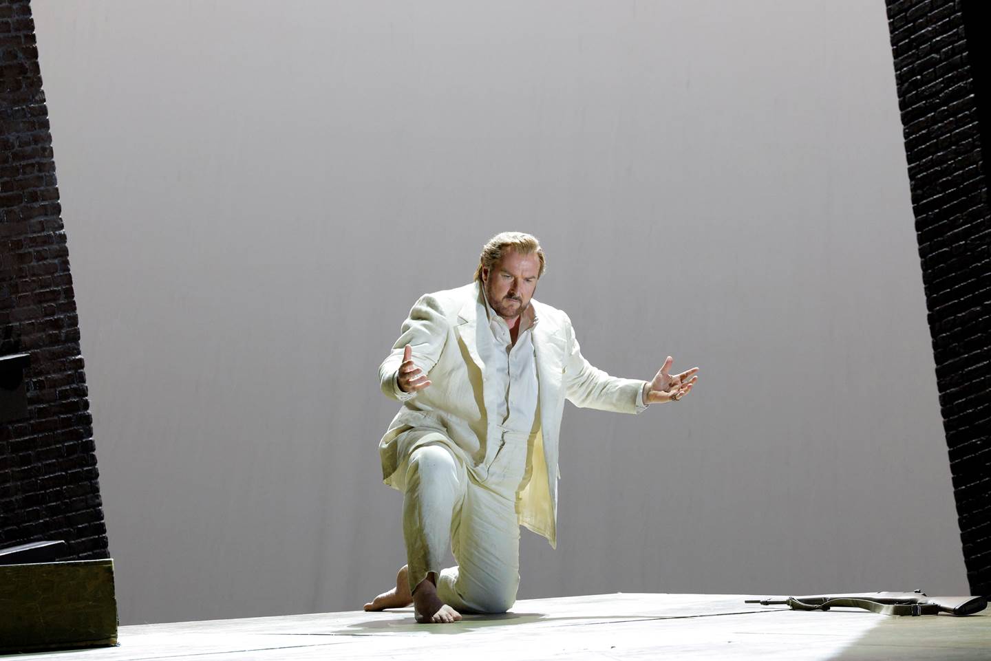 man kneeling on stage singing