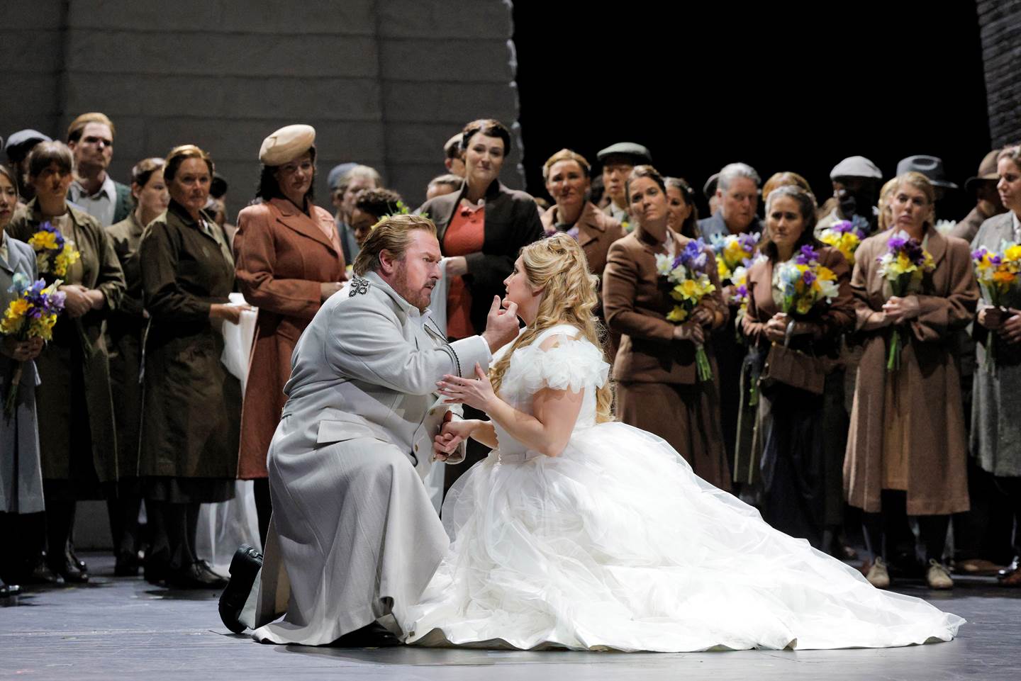 couple kneeling down on stage in front of onlookers
