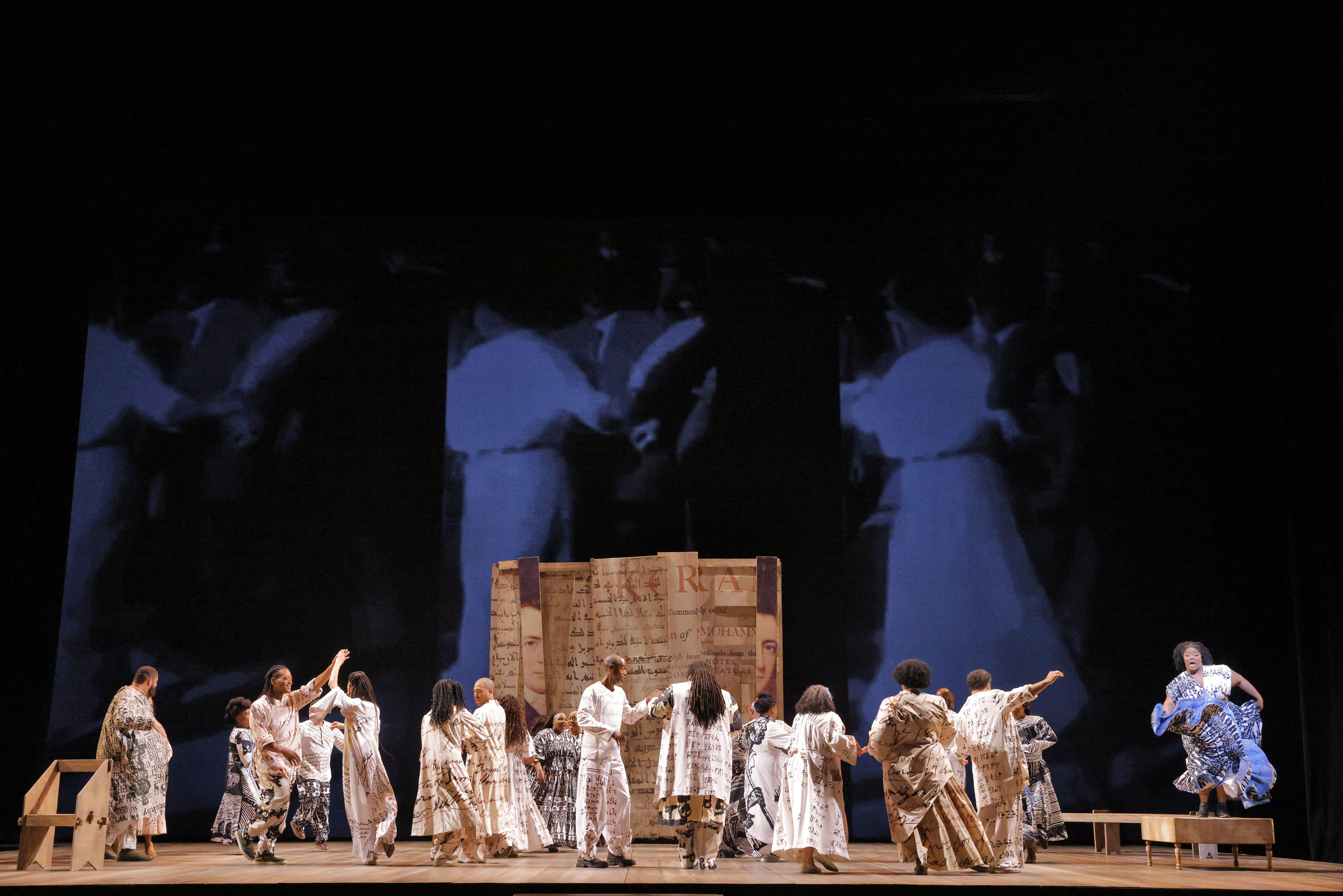 people on stage dancing with video in background