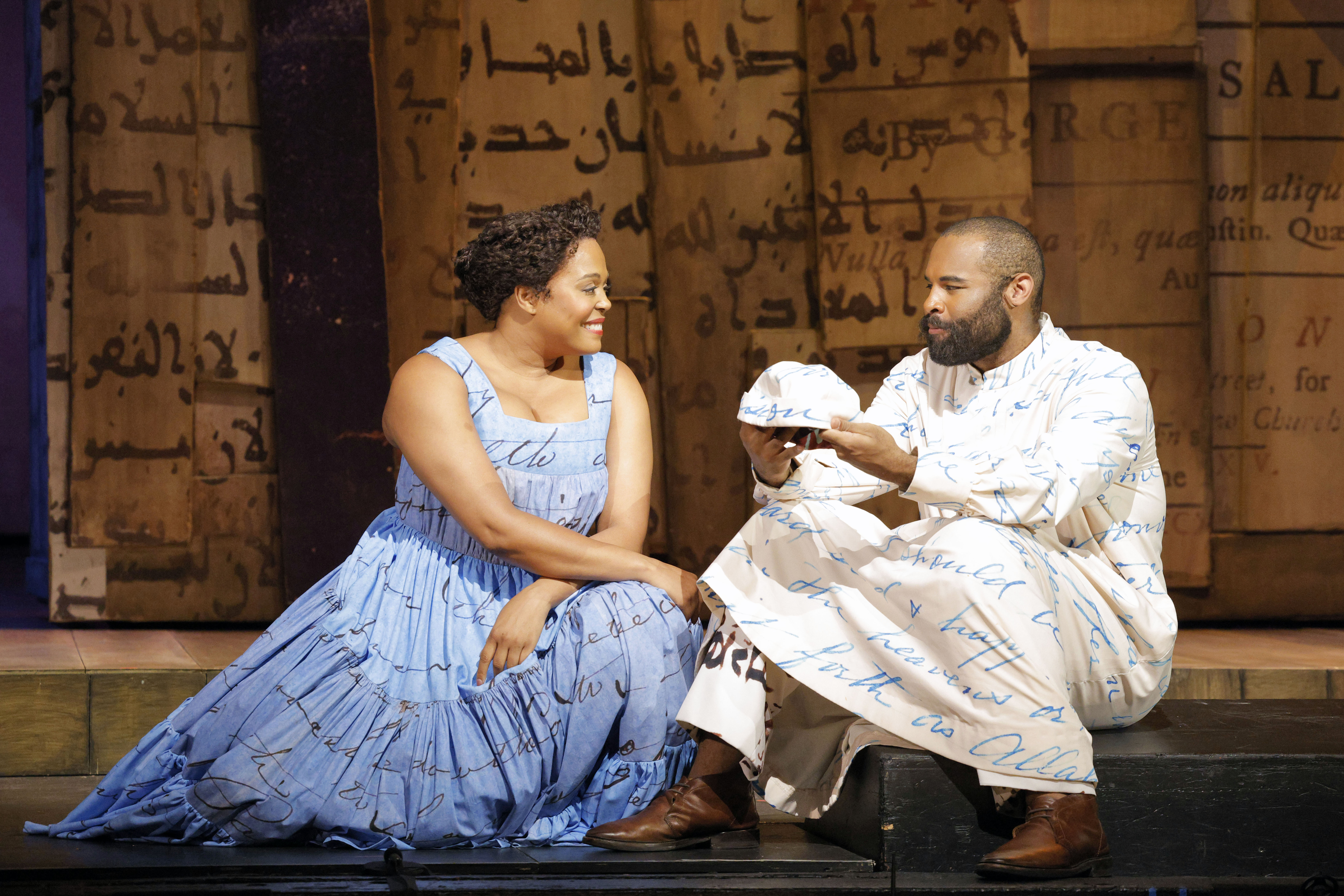man and woman seated facing each other and man is holding his cap.