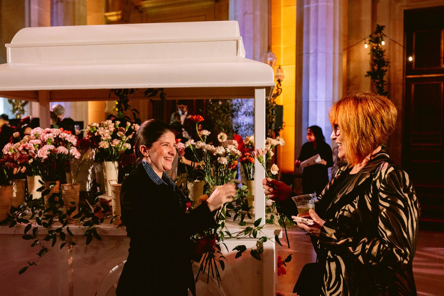 Opera volunteer handing out flowers to guests