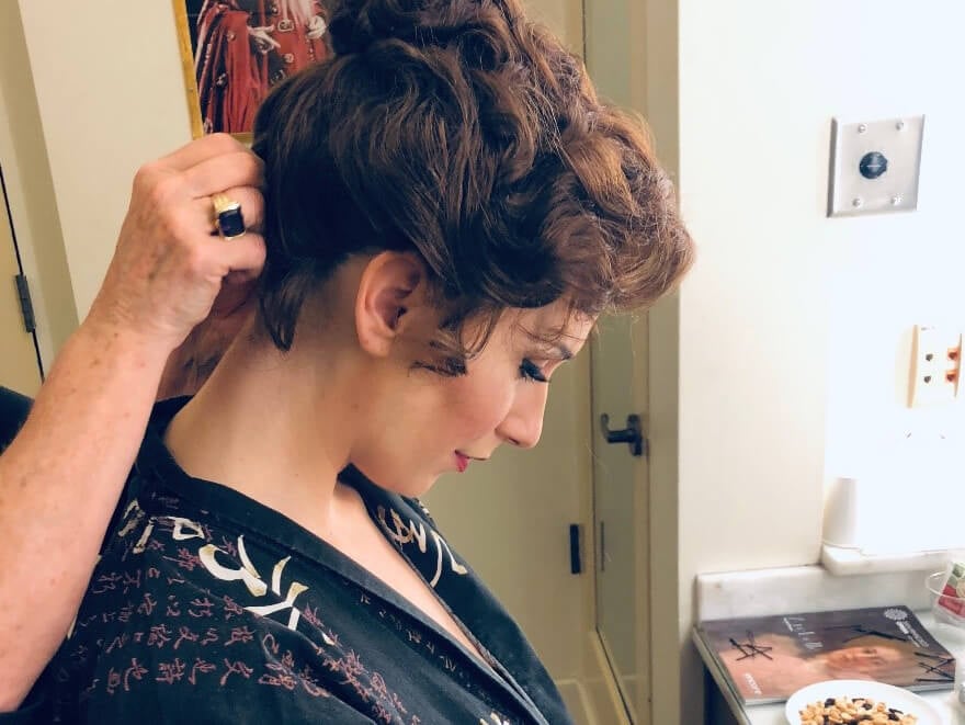 Ellie having her wig put on with wig and make-up artist Melanie Birch; Ellie&rsquo;s make-up kit for Arabella. (Photo: Jenna Wolf / Lenny&rsquo;s Studio)
