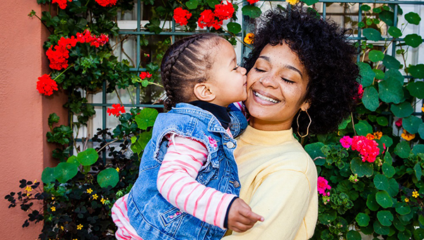 little girl kissing a woman on the cheek