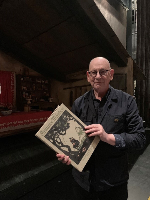 Antony McDonald on set with a Brothers Grimm book of fairy tales.