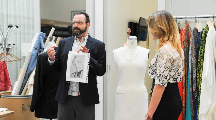 Christopher Verdosci holding up the design for the white dress.