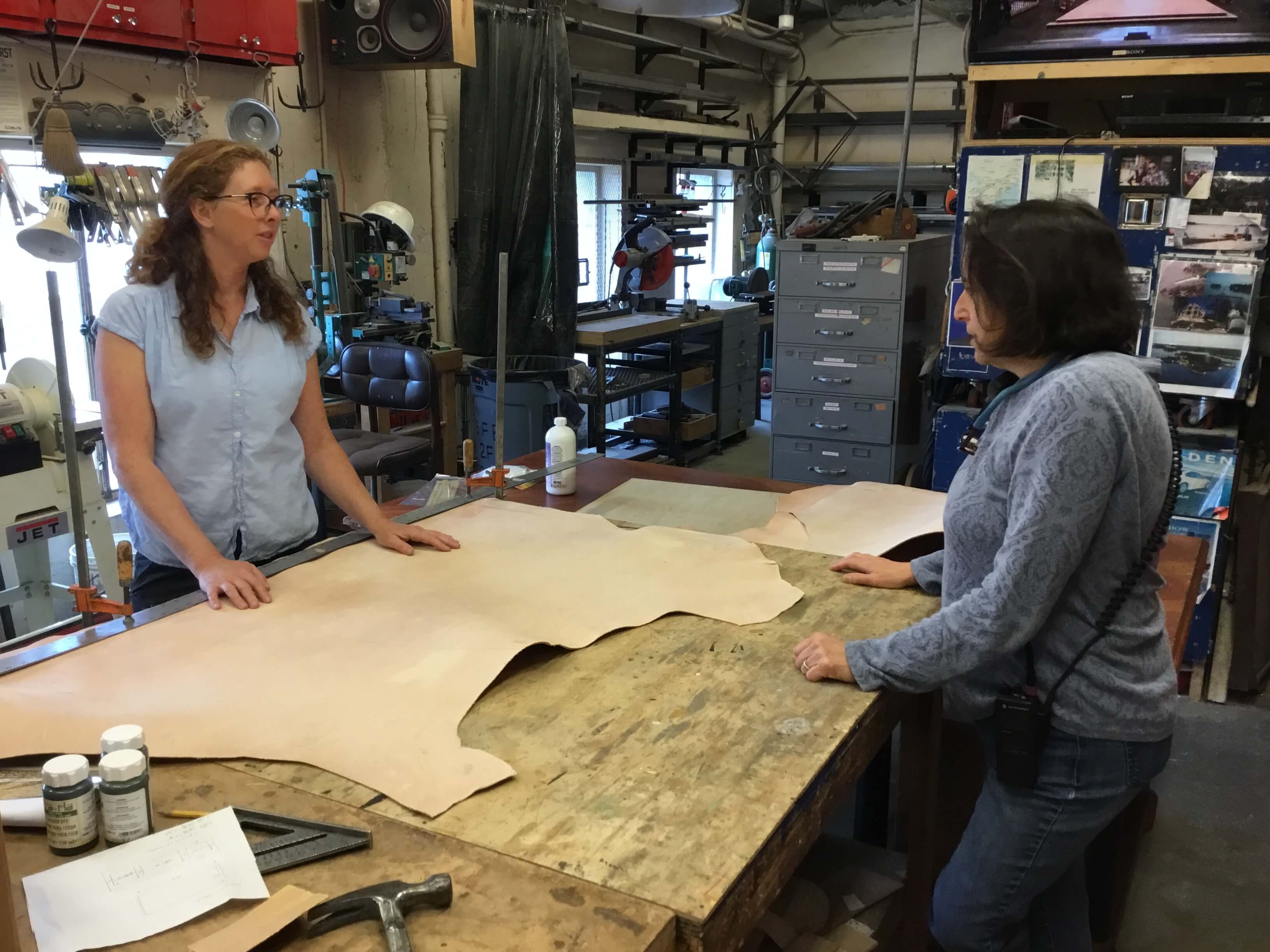 Sarah Shores, in conversation with Properties Master, Lori Harrison, talking about the leather before it is cut for Scarpia&rsquo;s desk (and the to-be-worked-on desk).