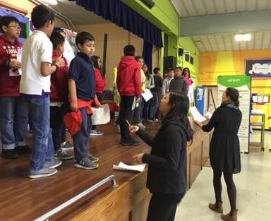 Ms. Carion and Katie working together with the class onstage.