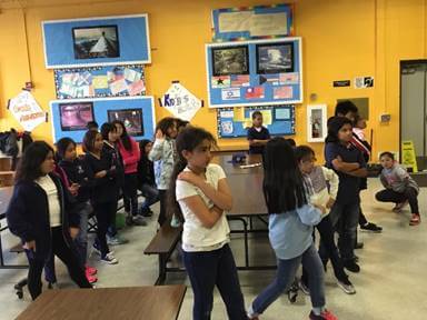 SFO teaching artist Katie Issel Pitre working with Mr. Won&rsquo;s 4th grade class, helping them express emotion through physicality.
